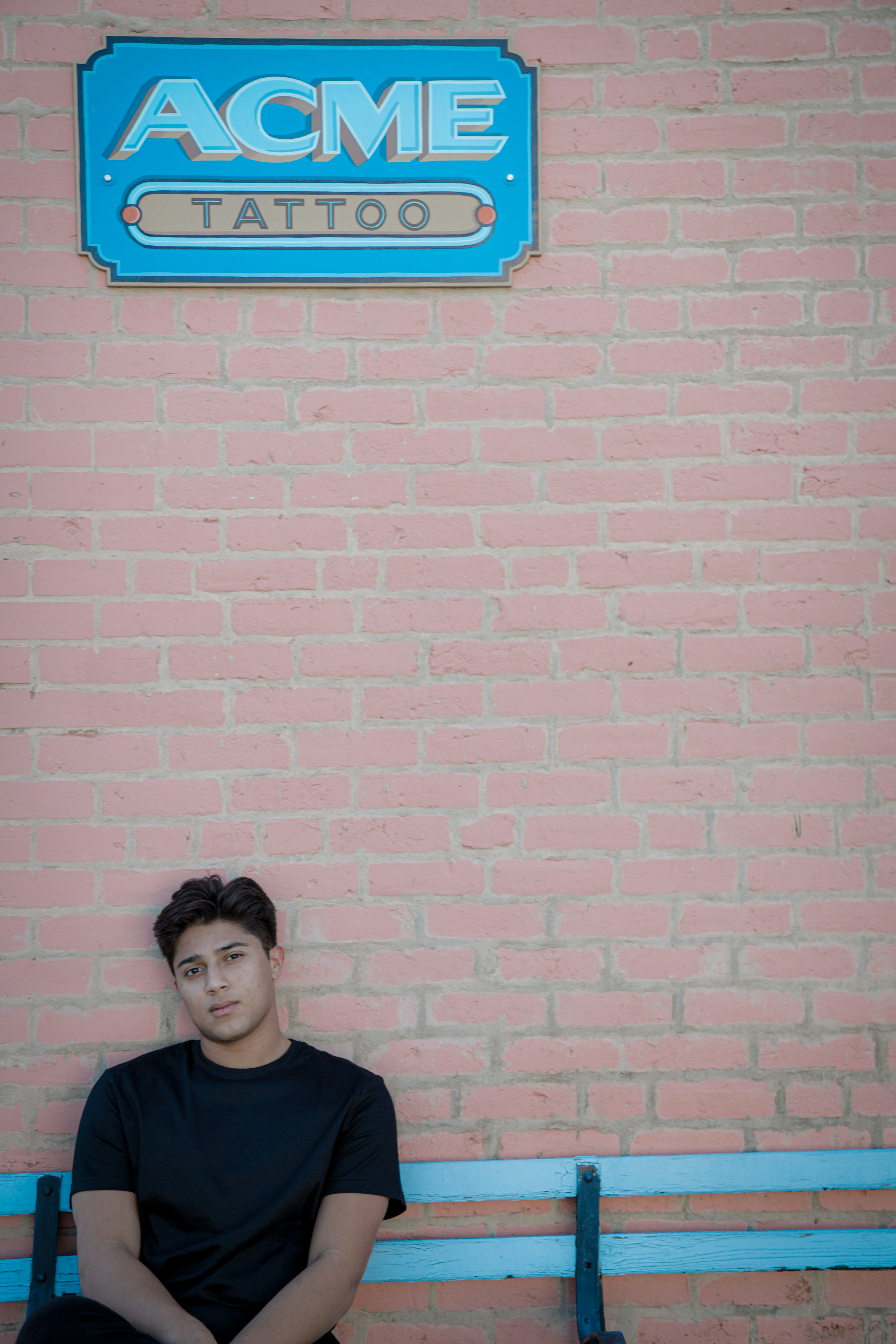 woman in black shirt standing beside brown brick wall